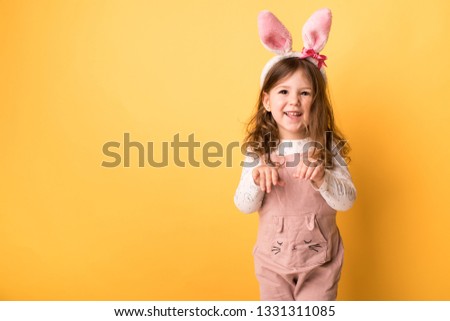 little girl with bunny ears on a yellow background