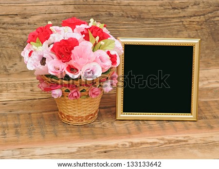 gold picture frame with paper flowers on wooden background