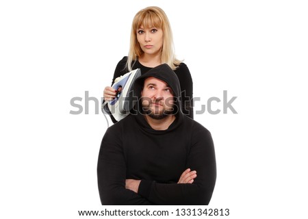 A funny scene. The blonde with the iron costs over the guy in a jacket with a hood. Happy couple of young people on a white background. meme Funny picture. Picture as a famous meme. Funny young people