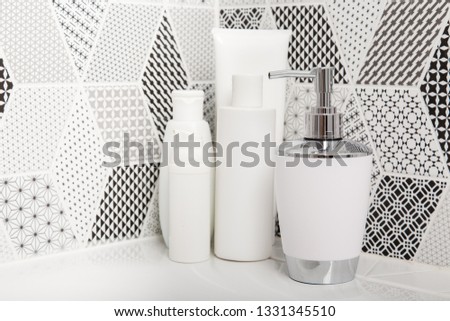 Bathroom, body care products and towel . Bath preparation. White interior of bathroom. Shampoo, shower gel and other bathing accessories. Toothbrush and soap dispenser. details of bathroom 