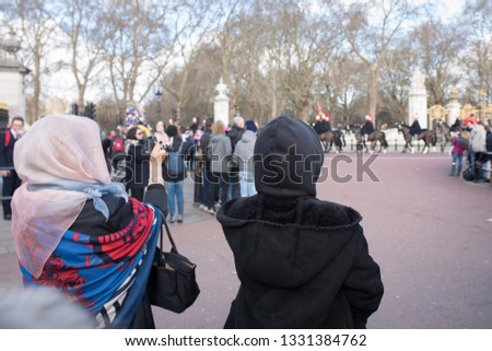 Tourists taking pictures of a parade at Buckingham Palace
