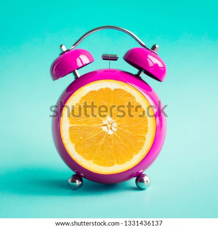 Summer time concepts ideas with orange alarm clock on blue pastel background.