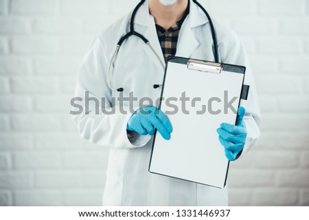 male doctor showing a blank clipboard isolated on white background