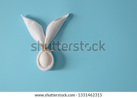 Easter table decoration with napkin in the form of rabbit ears and eggs. Festive Easter minimalism. Royalty-Free Stock Photo #1331462315