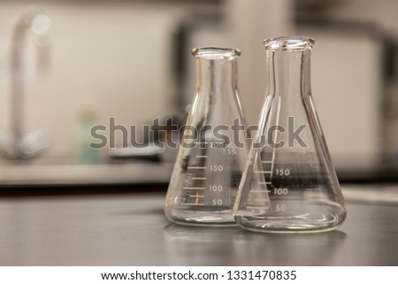 Brightly lit scientific apparatus resting on a darkly worn counter within a laboratory