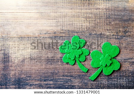 Decorative leaf of clover, trefoil, shamrock leaves on wood background, close up. Happy St. Patrick's Day holiday symbol.