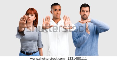 Group of three friends making stop gesture with her hand