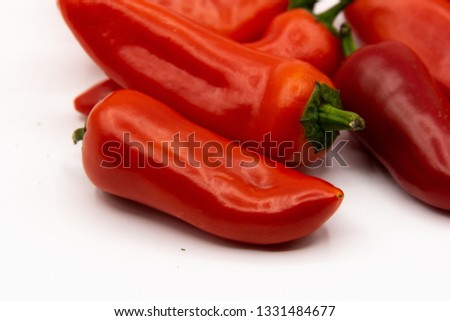 Closeup with detail of peppers piled on a seamless white background.