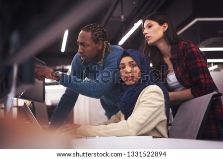 young multiethnics business team of software developers working together using laptop computer while writing programming code at modern startup office