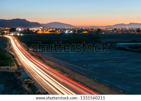 Long exposure of light trails of cars on a countryside road at night