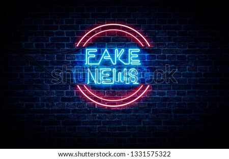 A neon sign in blue and red light on a brick wall background that reads: FAKE NEWS