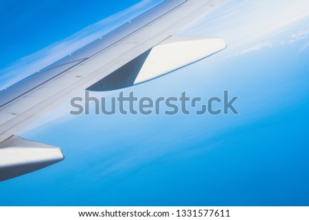 Airline wing fly in cloudy blue sunny sky. Tourist passenger experience full service of long haul flight in holiday, vacation travel, business trip. 