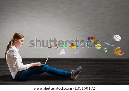 young girl sitting on the floor with a laptop from which emerge the signs and symbols