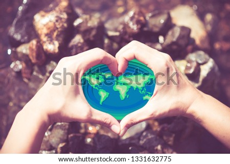 Love earth save our planet paper cut on woman's hand heart shape
