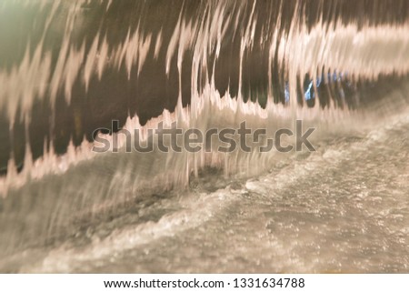 Abstract and close up of transparent falling water vertical flows.