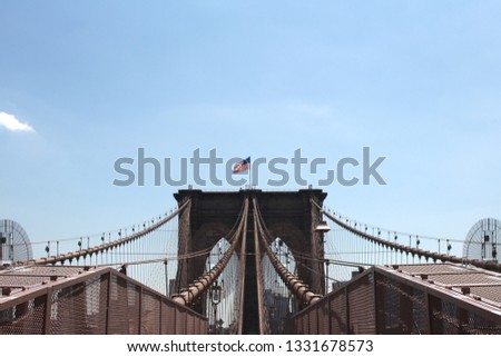 Details of the Brooklyn Bridge: towers, cables and the flag of the Unites States of America