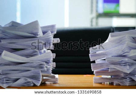 The paper stack of Documents on the desk.