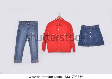 Red jeans jacket on hanging with blue jeans, skirt - white background
