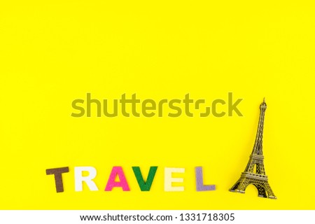Flat Lay with eiffel tower model on yellow colourful trendy modern fashion background. Vacation travel summer weekend sea adventure trip concept