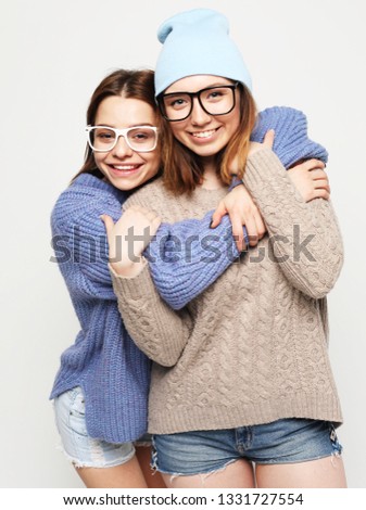 two pretty teen girlfriends smiling hugs and having fun