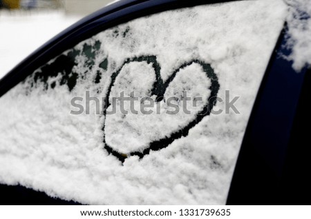 heart of snow on the door or glass of the car I love you 