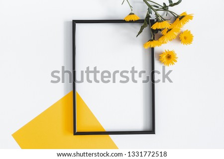Flowers composition. Yellow flowers, photo frame on pastel gray background. Spring, summer concept. Flat lay, top view, copy space