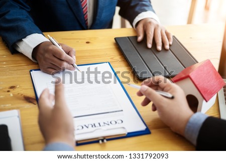 Business people discussion and negotiating investment housing estate with sign a contract term loan facility in office. contract and agreement concept.
