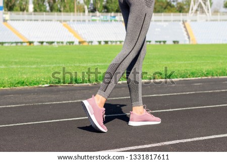 Ready to go. Close up photo of shoe of female athlete on the starting line. Girl on Stadium track, preparing for a run. Sports and healthy concept.