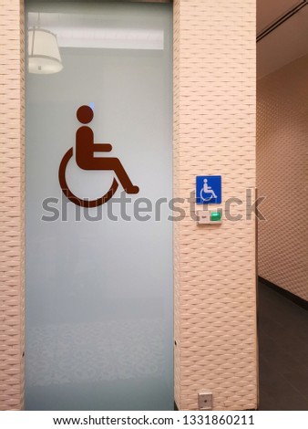 wheelchair symbol on toilet icon​ signs on a cement​ wall.