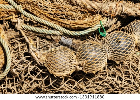 Close-up of old fishing nets with ropes and floats in the shape of a sphere. Full frame