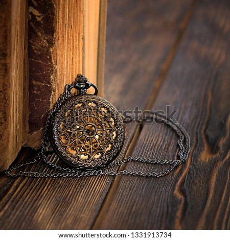 beautiful amulet and old books. inspiring picture with books. retro watches and vintage books. close up. vintage retro style, toning. soft selective focus