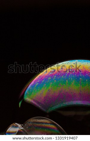 A bubble in rainbow colors on a black background.