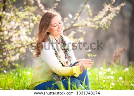 Beautiful woman enjoying daisy field, pretty girl relaxing outdoor