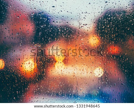 Drops Of Rain On Blue Glass Background. Street  Bokeh Lights Out Of Focus. Autumn Abstract Backdrop
