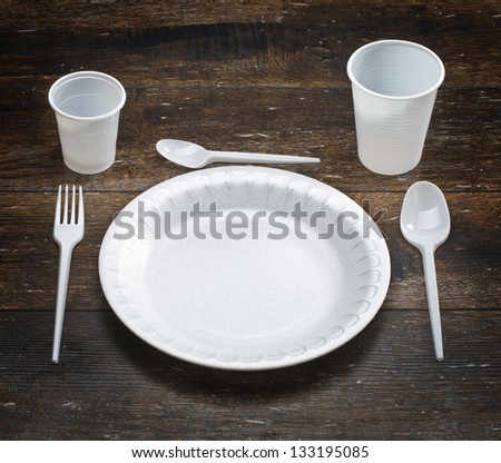 white disposable dishware set in a dark wood Royalty-Free Stock Photo #133195085