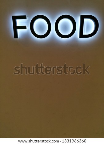 word food sign​ with​ white​ lighting​ on​ the​ wall​ yellow​ background​