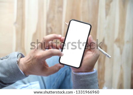 Man using mobile smartphone at wood table
