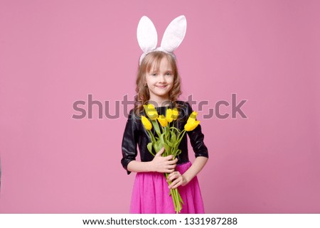 Funny girl in the shape of an Easter Bunny with a bouquet of yellow tulips. Concept of holidays, beauty and fashion. Selective focus.