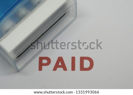 Stamped as paying red and white on white paper