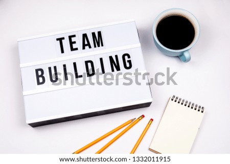 Team Building. Text in lightbox. White desk with stationery