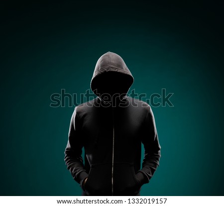 Computer hacker in hoodie. Obscured dark face. Data thief, internet fraud, darknet and cyber security concept.