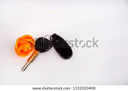 Car keys. Keys with an orange flower. Car key and alarm system isolated on white background. A gift to your loved one. flower. orange flower.