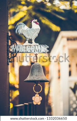 vintage wooden sign "Welcome" with a bell under the sign on door of cafe