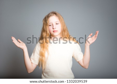 little teen girl weighs options, studio photo over background