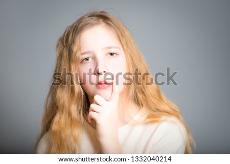little teen girl thoughtful, studio photo over background