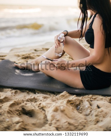 sport and lifestyle concept - woman doing sports by sea. Beautiful teenage sport woman doing stretching exercise on sand beach