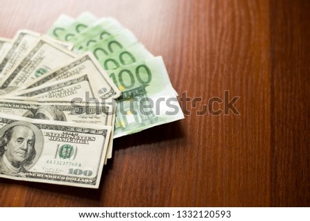 US dollars and euro banknotes texture. dark wood Background of one hundred dollar and euro bills.