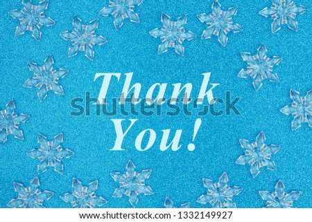 Thank you message with snowflakes on a blue glitter paper