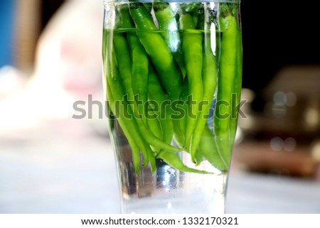 Green Chilli in the water glass Royalty-Free Stock Photo #1332170321