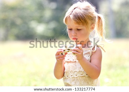 beautiful young girl on nature with binoculars